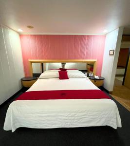 una camera da letto con un letto grande con una parete rossa di Autoparador Del Valle a Città del Messico