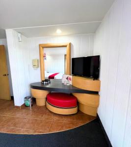 una camera d'albergo con una scrivania e una televisione di Autoparador Del Valle a Città del Messico Altre 51 foto
