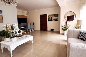 un salon avec une table blanche et un canapé dans l'établissement Goistay Descubre el Encanto nico de Repblica Dominicana Bella Vista, à Los Prados