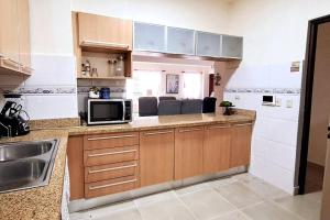 une cuisine avec un évier et un micro-ondes dans l'établissement Goistay Descubre el Encanto nico de Repblica Dominicana Bella Vista, à Los Prados