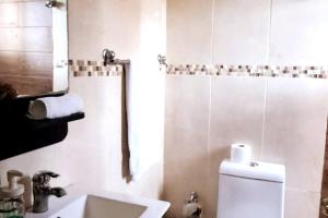 une salle de bain avec toilettes, lavabo et miroir dans l'établissement Goistay Descubre el Encanto nico de Repblica Dominicana Bella Vista, à Los Prados