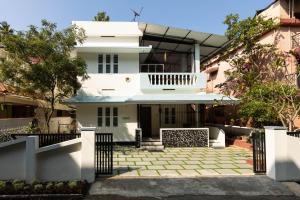 a white house with a gate in front of it at Chitralayam Home stay in Guruvāyūr