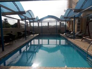 a swimming pool with blue water in a building at Ayalla Hotel Suites-yenogoa Royal Room in Port Harcourt