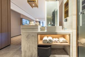 bagno con lavandino e bancone con asciugamani di Atour X Hotel Wuhan Railway Station West Square a Wuhan