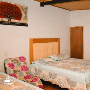 ein Schlafzimmer mit zwei Betten und einem Bild an der Wand in der Unterkunft Nice Quadruple Cabin Equipped And Very Central in Zacatlán