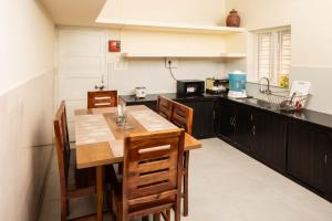 a kitchen with a table and chairs in a kitchen at Chitralayam Home stay in Guruvāyūr