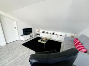 a living room with a couch and a tv at 6pers Modern harbor house Jasmijn with fenced garden and lake view in Anjum