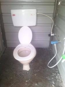 uma casa de banho com um WC branco numa cabina em Swiss Tents in Ooty, Tn em Ooty
