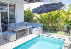 a patio with a table and an umbrella next to a pool at New beautiful house in El Tigre, Golf Club, Punta Cala 205 in Nuevo Vallarta 