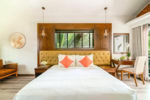 a bedroom with a large white bed with orange pillows at Famiana Resort & Spa - Breakfast is served as Brunch 6AM30 to 1PM in Phu Quoc +73 photos
