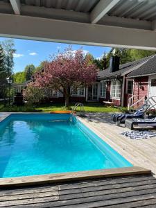 a swimming pool in front of a house at Charming property with private pool in Märsta