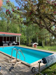 a swimming pool on a deck next to a house at Charming property with private pool in Märsta