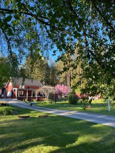 a house in a park with a tree at Charming property with private pool in Märsta