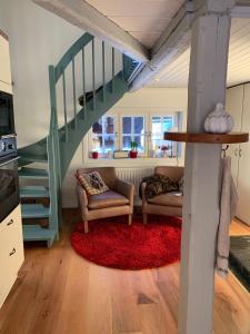 a living room with two chairs and a staircase at Charming property with private pool in Märsta