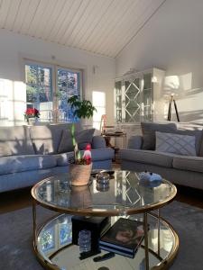 a living room with a table and a couch at Charming property with private pool in Märsta