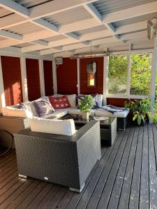 a porch with a couch and chairs on a deck at Charming property with private pool in Märsta