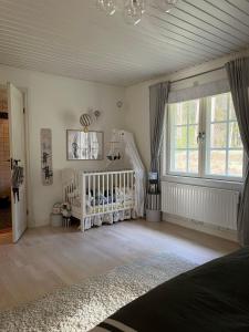 a baby room with a crib and a crib at Charming property with private pool in Märsta