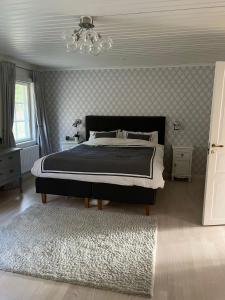 a bedroom with a large bed and a rug at Charming property with private pool in Märsta +37 photos