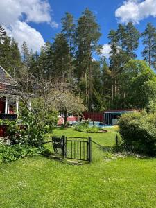 a park with a fence in the grass at Charming property with private pool in Märsta