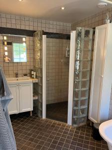 a bathroom with a shower and a sink at Charming property with private pool in Märsta