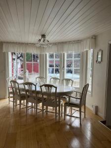 a dining room with a white table and chairs at Charming property with private pool in Märsta