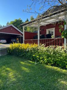 a house with a fence and flowers in the yard at Charming property with private pool in Märsta