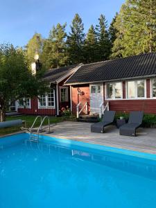 a house with a swimming pool in front of a house at Charming property with private pool in Märsta