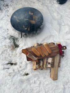 a wooden bench in the snow with a snowboard at Charming property with private pool in Märsta