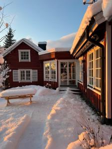a house with a bench in the snow at Charming property with private pool in Märsta