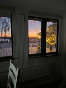 a room with three windows and a white chair at Charming property with private pool in Märsta