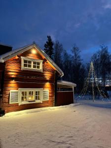 a wooden house with a christmas tree in the background at Charming property with private pool in Märsta