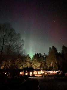 a green aurora in the sky over a house at Charming property with private pool in Märsta