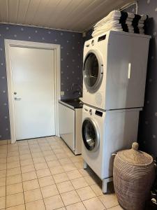 a laundry room with a washer and dryer at Charming property with private pool in Märsta