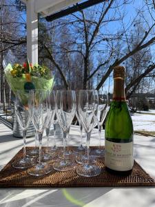 a group of wine glasses and a bottle of wine at Charming property with private pool in Märsta
