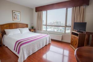 1 dormitorio con 1 cama y TV de pantalla plana en MR Apart Providencia (ex Apart Neruda) en Santiago