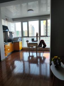 un soggiorno con tavolo e sedie di fronte alle finestre di 博博家精品民宿 a Harbin