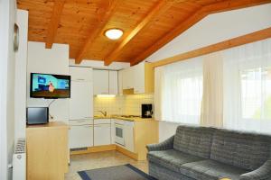 a living room with a couch and a kitchen at Ferienwohnungen Schöpf in Jerzens