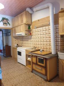 a kitchen with wooden cabinets and a white stove at Casa Di Collina Nelle Langhe Typical country house in Belvedere Langhe