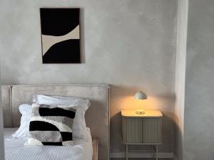a bed with a black and white pillow and a lamp at Martha's House in Alba Iulia
