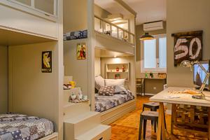 a small room with two bunk beds and a table at Bcn Paseo De Gracia Rocamora Apartment in Barcelona