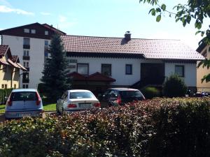 drei Autos auf einem Parkplatz vor einem Haus geparkt in der Unterkunft Apartment CDR in Zreče