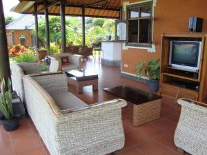 a patio with wicker chairs and a table and a television at Villa Bali Pondok Jepang in Lovina +11 photos