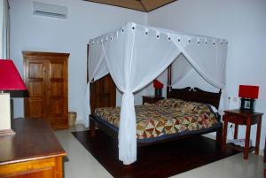 a bedroom with a bed with a canopy at Villa Bali Pondok Jepang in Lovina