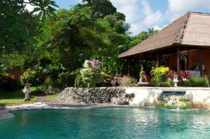 a swimming pool in front of a house at Villa Bali Pondok Jepang in Lovina