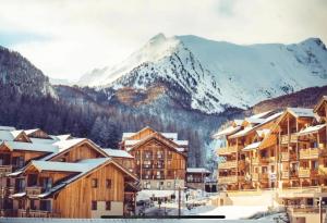 a town with snow covered buildings and a mountain at Les Orres 1800 - Spacieux T3 6 pers SUD Vue Piste in Le Mélézet