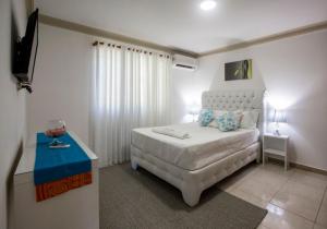 a bedroom with a white bed and a blue table at Cozy and Central apartment 1br-1ba with Pool in Sosúa