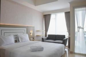 Ένα ή περισσότερα κρεβάτια σε δωμάτιο στο Fully Furnished with Cozy Design Studio at Menteng Park Apartment By Travelio +15 φωτογραφίες