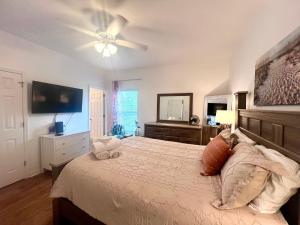 a bedroom with a large bed and a flat screen tv at 4014 Rookery 3 Cottage with two Pools and Beach Amenities in Gulf Highlands