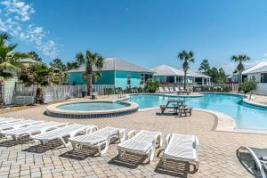 a swimming pool with lounge chairs and a table and a picnic table at 4014 Rookery 3 Cottage with two Pools and Beach Amenities in Gulf Highlands +101 photos