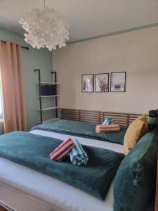 Zwei Einzelbetten in einem Schlafzimmer mit Kronleuchter in der Unterkunft Eure Auszeit überm See in Markdorf